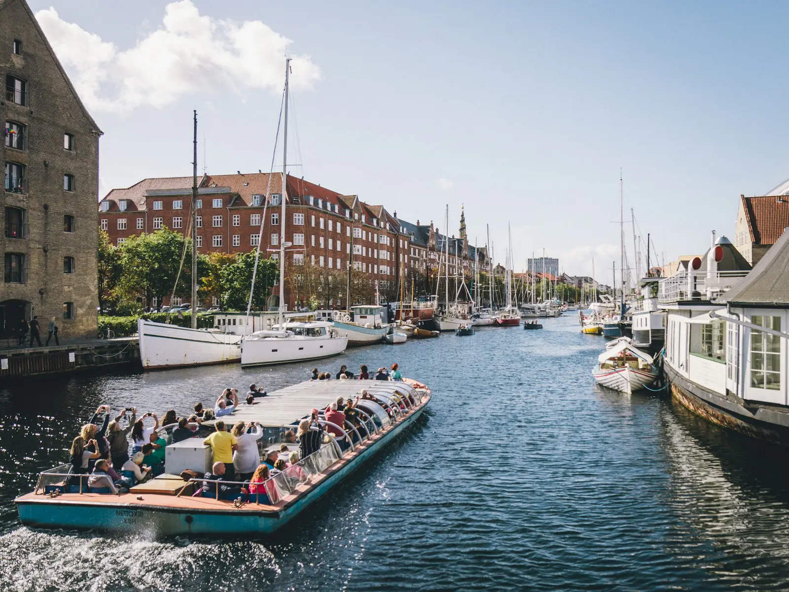 A tour boat with passengers in a harbour canal