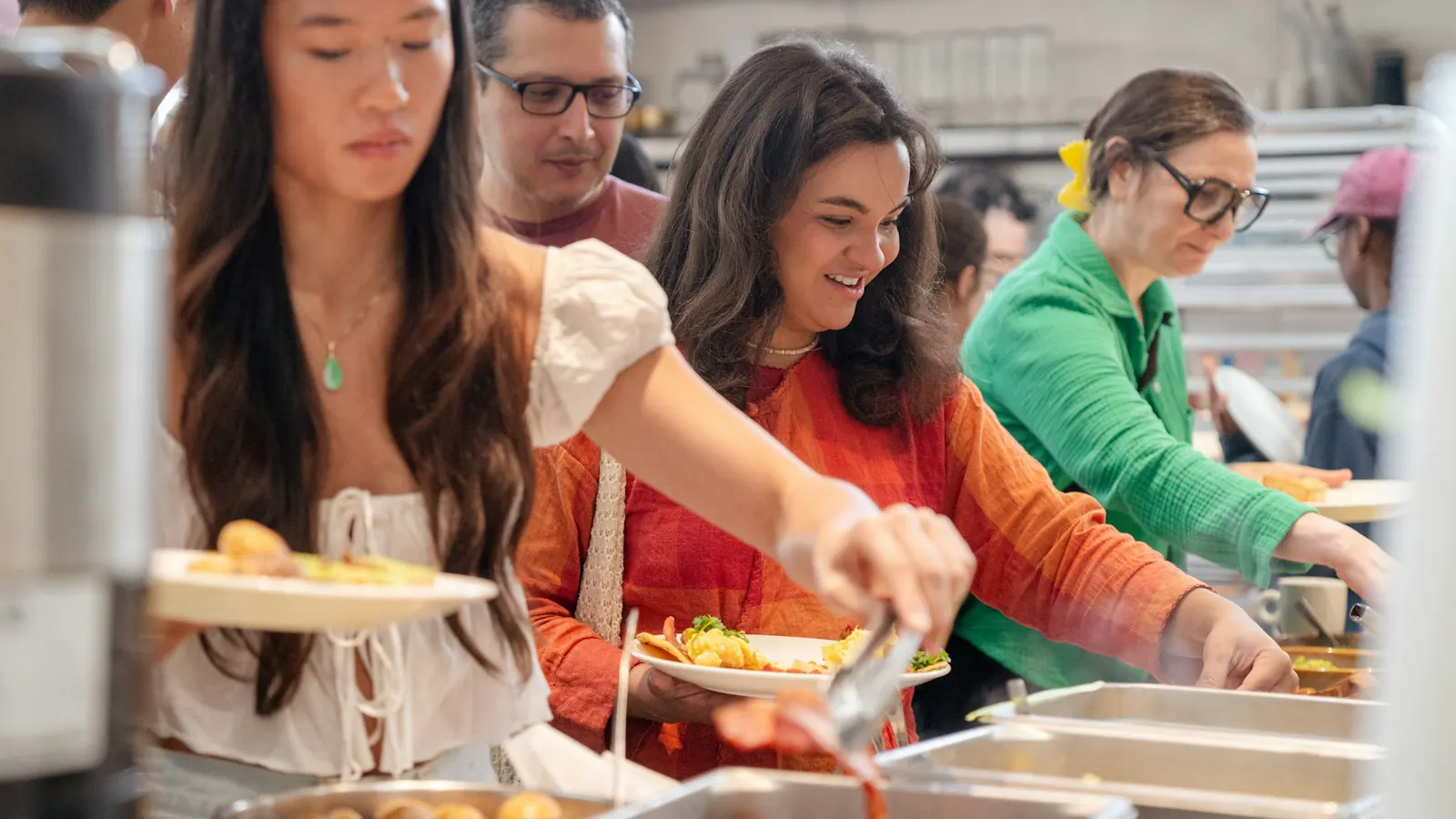 Volunteers serving food at a buffet